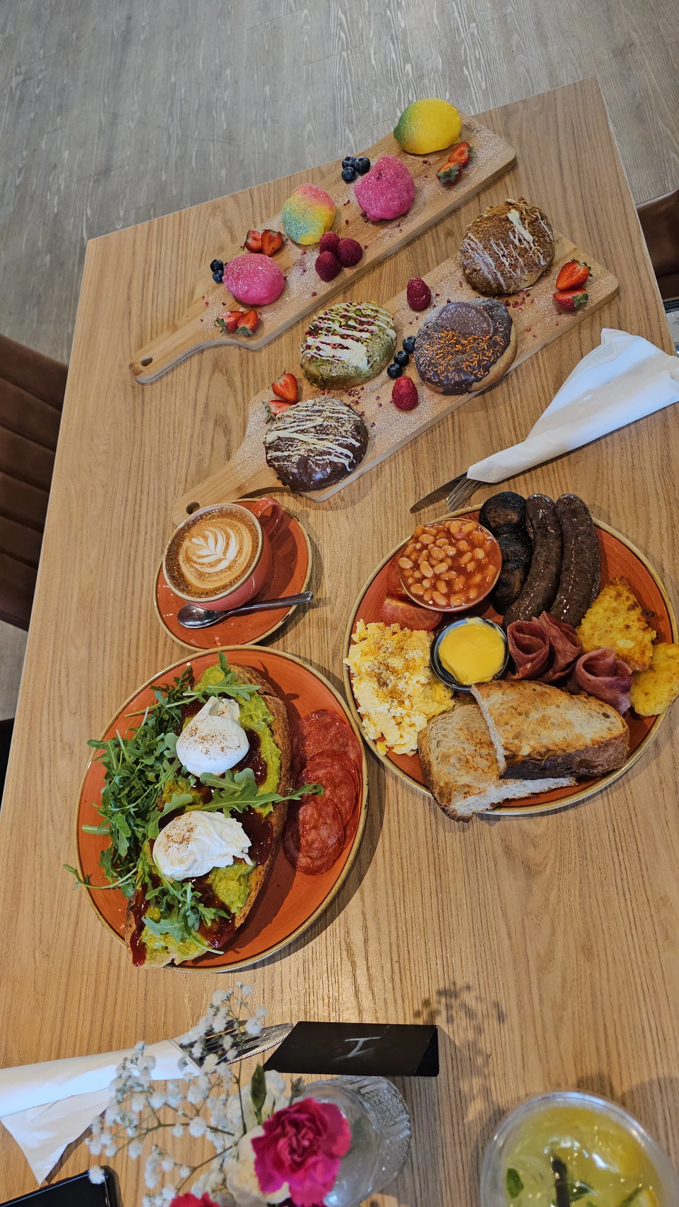 Breakfast plates, coffee, cookies and colourful fruit patisserie on a cafe table